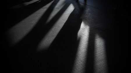 Shadow of a man standing in a dark room with his shadow in the background