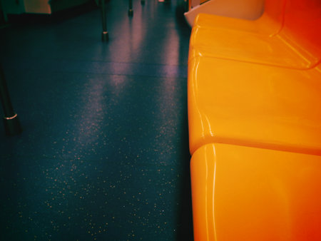 Interior of a train station with orange seats and black floor.の写真素材