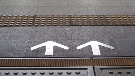 Two white arrows on the walkway of a train station in Paris
