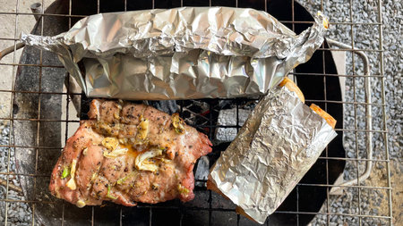 grilled meat in foil on the coals of the brazierの写真素材