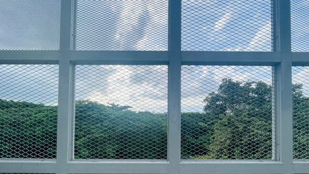 Glass window with blue sky and green trees in the background, stock photoの写真素材