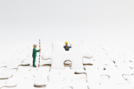 Miniature people the team is working on a jigsaw puzzle , Team work conceptの写真素材