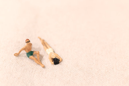 Miniature people , Couple sunbathing together on The beachの写真素材