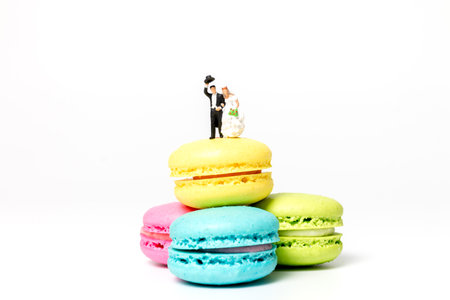 Miniature people , Bride and groom on colourful french macaroon , Valentines day conceptの写真素材