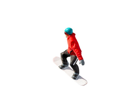 Miniature figurine depicting a snowboarder in mid-motion isolate on white background with clipping pathの写真素材