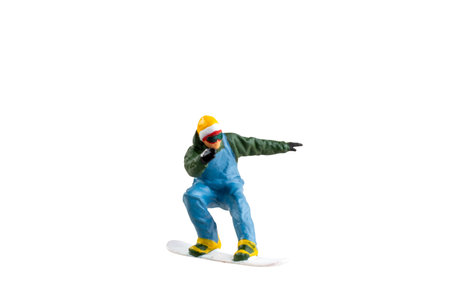 Miniature figurine depicting a snowboarder in mid-motion isolate on white background with clipping pathの写真素材