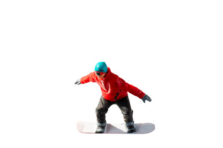 Miniature figurine depicting a snowboarder in mid-motion isolate on white background with clipping pathの写真素材