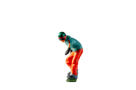 Miniature figurine depicting a snowboarder in mid-motion isolate on white background with clipping pathの写真素材
