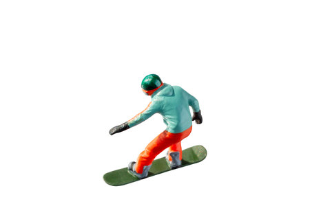 Miniature figurine depicting a snowboarder in mid-motion isolate on white background with clipping pathの写真素材