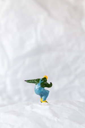 Miniature people  snowboarder dressed in vibrant winter gear, carving through a snowy slope. Ideal for winter sports, adventureの写真素材