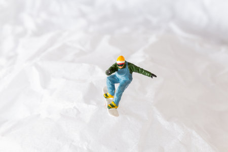 Miniature people  snowboarder dressed in vibrant winter gear, carving through a snowy slope. Ideal for winter sports, adventureの写真素材