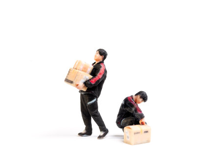 Miniature figurine of a delivery worker carrying  packages, showcasing logistics, shipping, and the concept of service and reliability in a creativeの写真素材