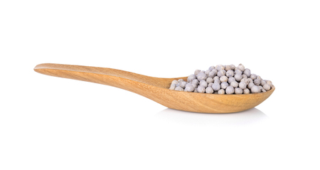 white pepper in wooden spoon isolated on white backgroundの写真素材