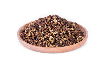 Dry Zanthozylum limonella Alston in wooden bowl on white backgroundの写真素材