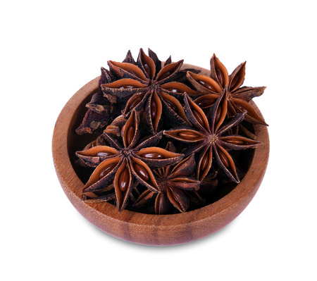 Chinese star anise seed in Chinese star anise seed in wooden bowl over the white backgroundの写真素材