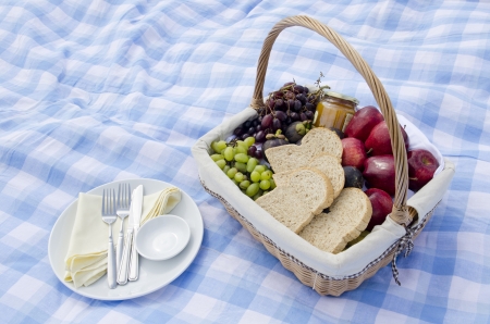 Pic-nic basket with fruit and dish on blue seamless plaid patternの写真素材