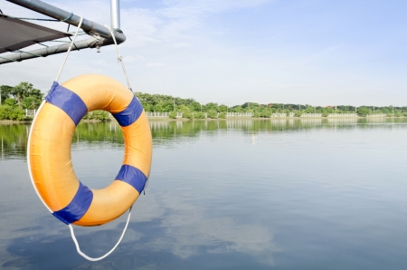 Lone orange life ring  in front of empty boat docks on a cloudy rainy day with no boatsの写真素材