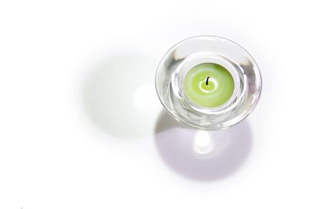 Green candle in glass with shadow   の写真素材