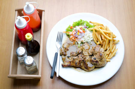 Pork Steak, French fries and vegetables Salad with Mix Sauce . 