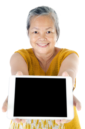 portrait of Asian senior woman with tablet on white background . の写真素材