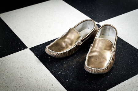 Old Golden shoes on black and white floor background . の写真素材