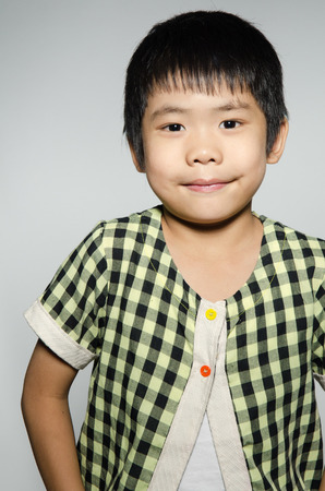 Portrait Of asian cute boy on gray background .の写真素材