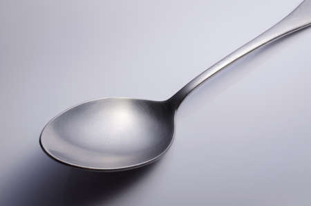 Used metal spoon. Isolated on gray background . の写真素材