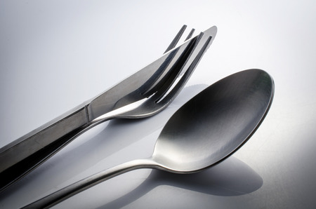 Used Cutlery set with Fork, Knife and Spoon isolated on gray background . の写真素材
