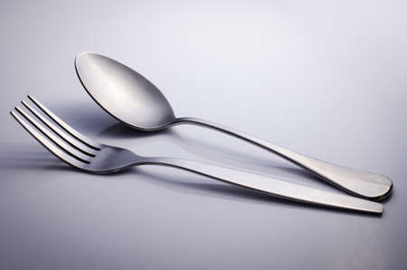 Used Cutlery set with Fork and Spoon isolated on gray background . の写真素材