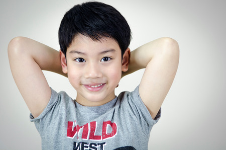 Portrait Of asian cute boy on gray background  