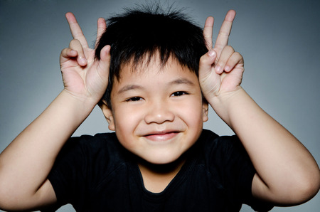 Portrait Of asian cute boy on gray background  の写真素材