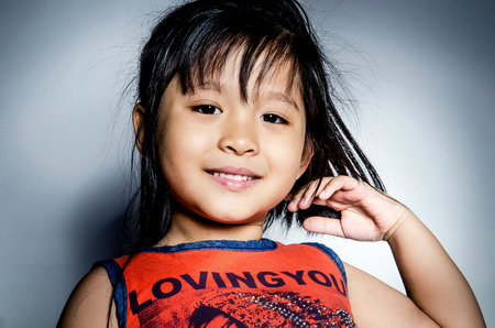 Portrait of happy asian cute Girl on gray background .の写真素材
