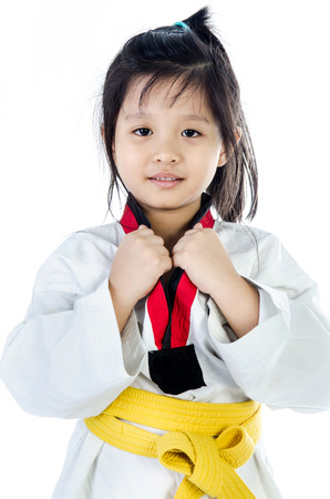 little asian girl in a kimono with a yellow sash on a white backgroundの写真素材