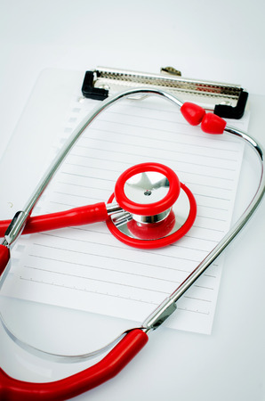 Stethoscope with plastic clipboard , blank paper and pen on gray .の写真素材