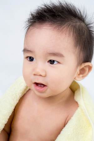 Beautiful smiling asian cute baby,Little boy with yellow  bath towel ,looking her motherの写真素材