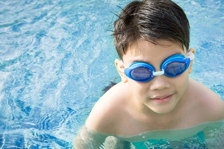 Portrait of happy asian little boy playing in the poolの写真素材