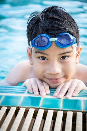 Portrait of happy asian little boy playing in the poolの写真素材