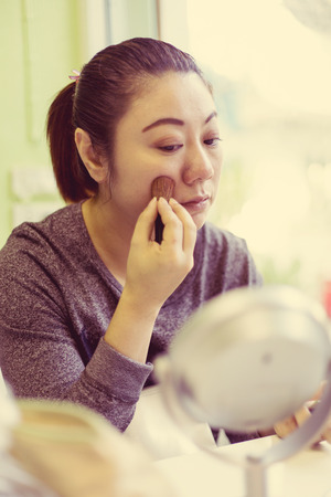 portrait of asian beautiful woman with brush for make-up . vintage styleの写真素材