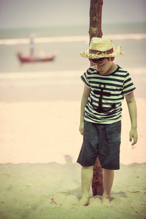Happy asian boy playing on tropical beach, Vintage styleの写真素材