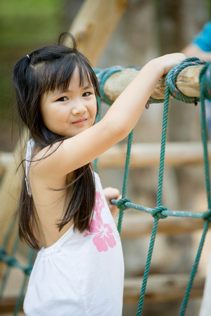 Happy asian cute Girl playing on playgroundの写真素材