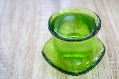 Vintage green glass with water on wooden backgroundの写真素材