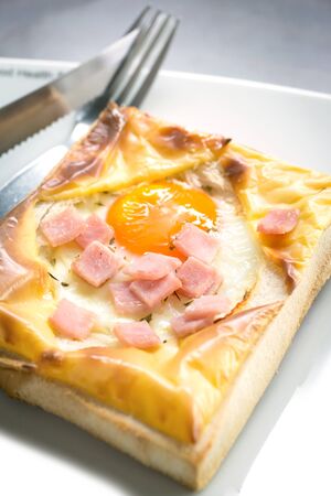 Cooked egg on toast,with fork and knife on white plate .の写真素材