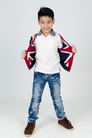 Little asian boy with smile face wearing winter clothes on gray backgroundの写真素材