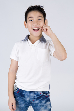 Little asian boy with surprise face on gray backgroundの写真素材