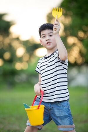 Happy Asian cute boy playing with toys in gardenの写真素材