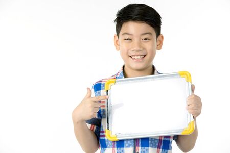 Asian boy is little smile with blank white board and looking camera on gray backgroundの写真素材