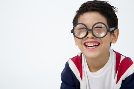 Portrait of happy asian boy ware glasses and laugh  on gray backgroundの写真素材
