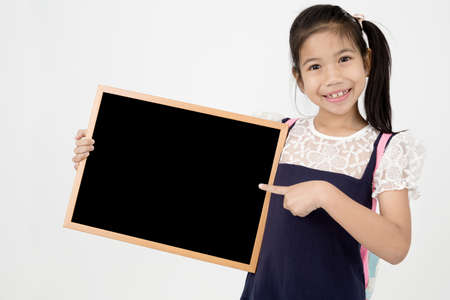 Happy Asian preteens girl hand holding wood board  on gray background with smile faceの写真素材