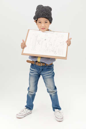 Happy Asian little artist boy holding a blank art board  on gray backgroundの写真素材