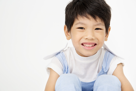 Happy asian cute boy with smile face on gray backgroundの写真素材